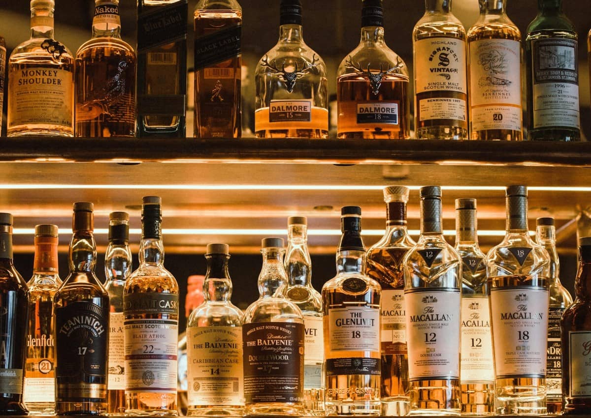 Different bottles of Scotch whisky of its various types in a bar shelf