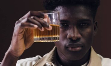 A man holding a glass of whisky