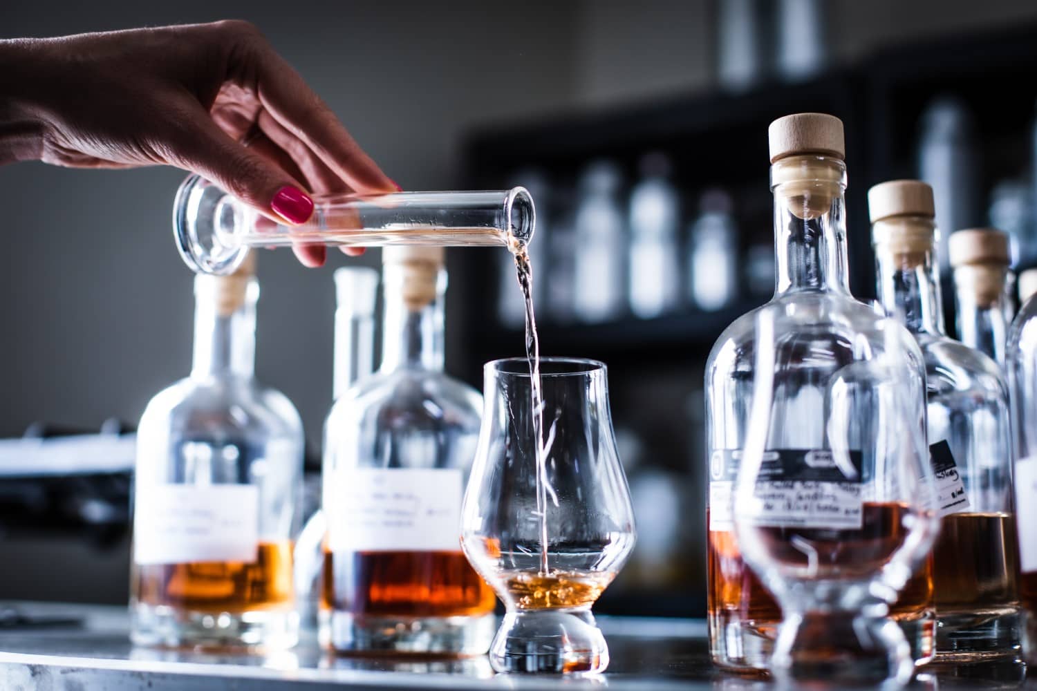 Person pouring whiskey into a glencairn glass