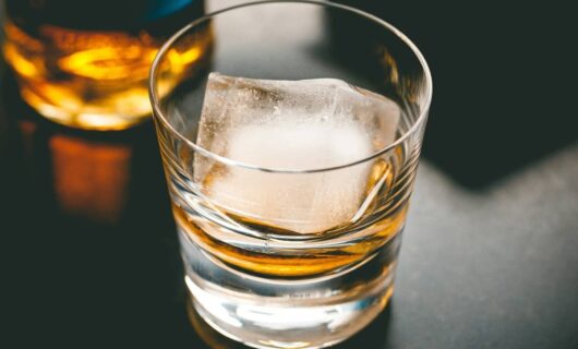 Glass of whisky on the rocks using a large ice cube