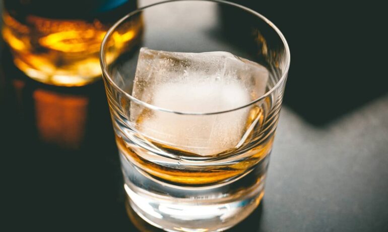 Glass of whisky on the rocks using a large ice cube